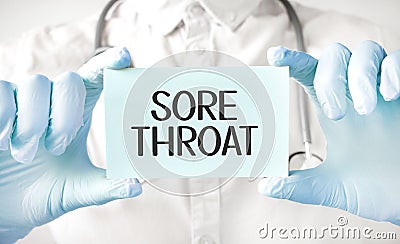Doctor holding card in hands and pointing the word SORE THROAT Stock Photo