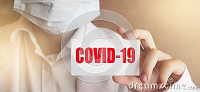 Doctor holding a card with text COVID-19 , medical healthcare concept Stock Photo