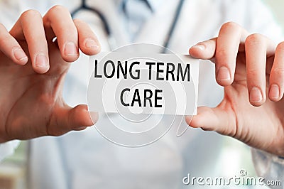 Doctor holding a card with text LONG TERM CARE Stock Photo