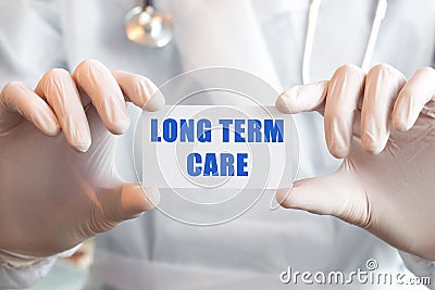 Doctor holding a card with text LONG TERM CARE, medical concept Stock Photo