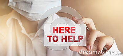 Doctor holding a card with Here to Help. Healthcare support medical concept Stock Photo