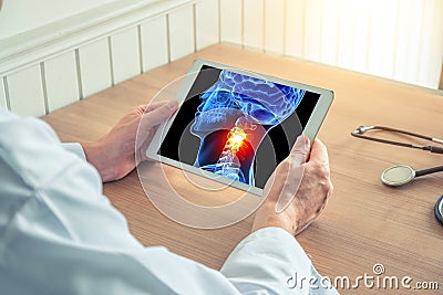 Doctor holding a digital tablet with x-ray of 3D skull with pain on the neck. Headache migraine or trauma concept Stock Photo