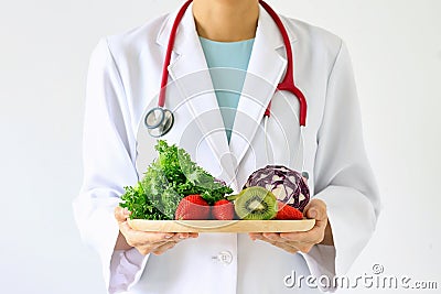 Doctor holding fresh fruit and vegetable, Healthy diet. Stock Photo