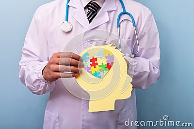 Doctor holding head with jigsaw puzzle brain shape - Autism spectrum disorder concept Stock Photo