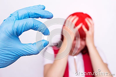 Doctor holding a headache pill that relieves stress and migraine, painkiller, antispasmodic Stock Photo