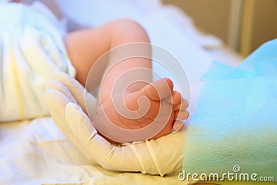 Doctor holding newborn child`s foot in hospital Stock Photo