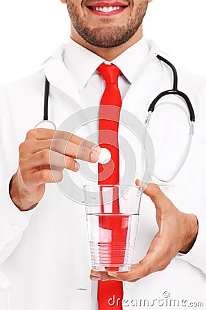 Doctor holding a pill and glass of water Stock Photo