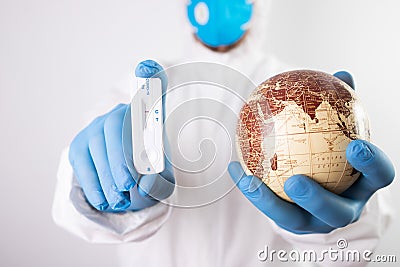 Doctor holding the planet Earth and coronavirus test Stock Photo