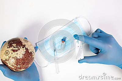 Doctor holding the planet Earth and coronavirus test Stock Photo