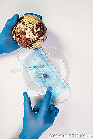 Doctor holding the planet Earth and coronavirus test Stock Photo