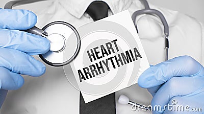 Doctor holding stethoscope and paper sheet woth text Heart arrhythmia. Medical concept Stock Photo