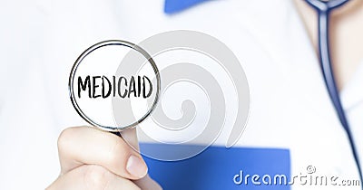 Doctor holding a stethoscope with text MEDICAID, medical concept Stock Photo