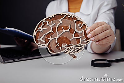 Doctor holding wooden brain. The importance of early diagnosis concept Stock Photo