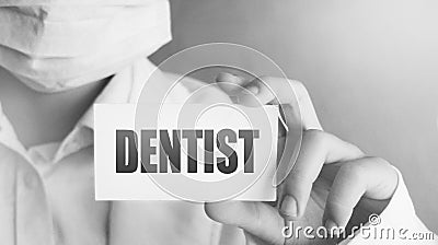 A doctor holds a card with word Dentist . Medical healthcare concept Stock Photo