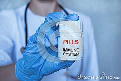 The doctor holds a jar of pills, a hand in medical gloves. On the bank there is an inscription on a medical theme Stock Photo