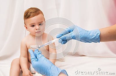 Doctor holds syringe to vaccinate sick baby with injection Stock Photo