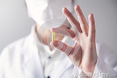 Doctor holds yellow pill in his hand. Medical concept Stock Photo