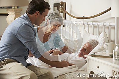 Doctor On Home Visit Discussing Health Of Senior Male Patient With Wife Stock Photo