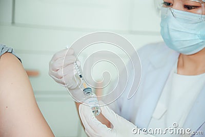 A doctor is injecting the monkeypox vaccine into the patient Stock Photo