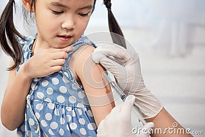 Doctor injecting vaccination in arm of asian little child girl Stock Photo