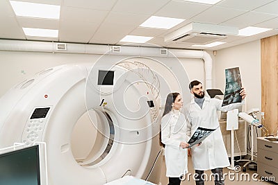 Doctor intern girl is studying in the CT computed tomography scanning room at internship courses. Colleague doctors Stock Photo