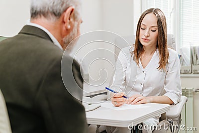 doctor interviews elderly man before being examined in ophthalmologist's office. Stock Photo