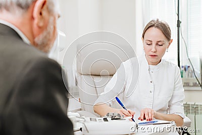 doctor interviews elderly man before being examined in ophthalmologist& x27;s office. Stock Photo