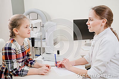 doctor interviews little girl before being examined in ophthalmologist& x27;s office. Stock Photo