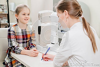 doctor interviews little girl before being examined in ophthalmologist& x27;s office. Stock Photo