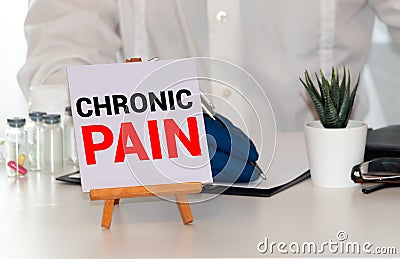 Doctor keeps a card with the name of the diagnosis chronic pain. Selective focus Stock Photo