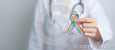 Doctor with LGBTQ Rainbow ribbon for Support Lesbian, Gay, Bisexual, Transgender and Queer community and happy Pride month concept Stock Photo