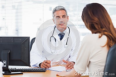 Doctor listening to his patient talking about her illness Stock Photo