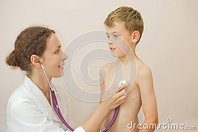 Doctor listens to lungs of boy with stethoscope Stock Photo