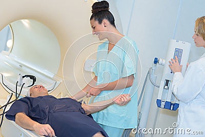 Doctor looking at female patient going through ct scan Stock Photo