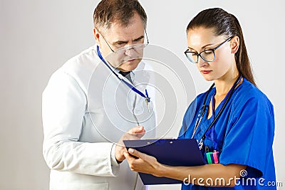 The doctor looks at the results of the nurse`s records in the card, while in the hospital Stock Photo