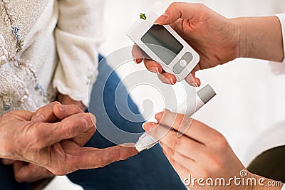 Doctor making diabetes blood test on senior woman, closeup Stock Photo