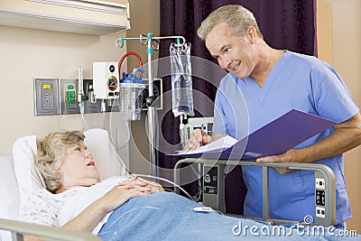 Doctor Making Notes About Senior Woman Patient Stock Photo