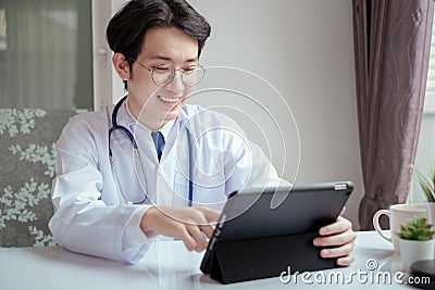 Doctor male working with tablet on desk clinic health care for pateint technology help support Stock Photo