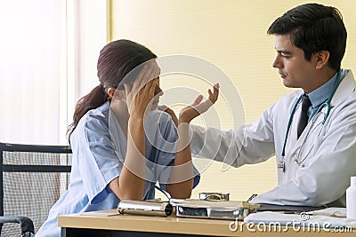 Doctor wear uniform with pen and stethoscope sitting in office while talking about problem health patient woman fell friendly Stock Photo