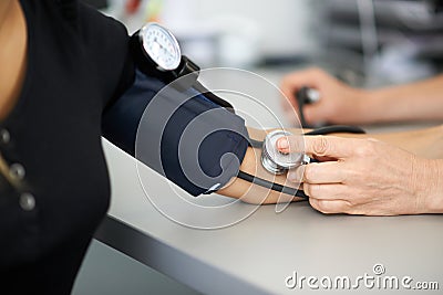 Doctor measures the blood pressure of a patient Stock Photo
