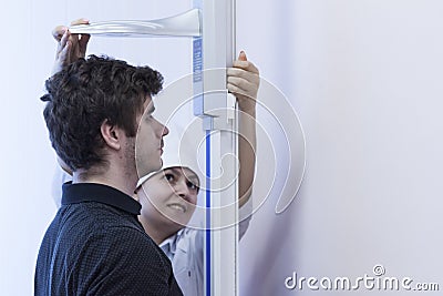 Doctor measures growth in medical office Editorial Stock Photo