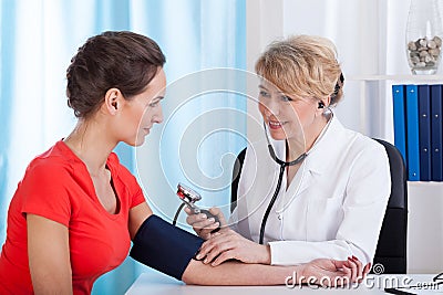 The doctor measures the pressure of woman Stock Photo