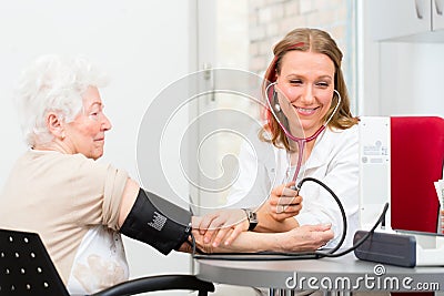 Doctor measuring blood pressure of senior patient Stock Photo