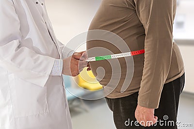 Doctor measuring obese man waist body fat. Obesity and weight loss. Stock Photo