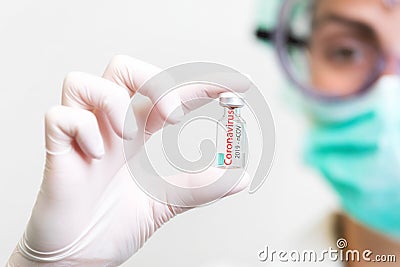 A doctor in medical gloves and mask holding an ampula with vaccine. Close up shot. Coronavirus, epidemic and medicine Stock Photo