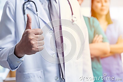 Doctor medical team with hand thumbs up positive sign for good care confirm virus protected service healthcare concept Stock Photo