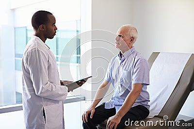 Doctor Meeting With Mature Male Patient In Exam Room Stock Photo