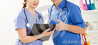 Doctor and nurse discussing something in the clinic. Two doctors in medical office close up image Stock Photo