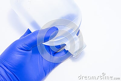 A doctor, nurse or medical professional holds in his hand, wearing a latex glove, a plastic bottle Stock Photo