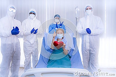 Sucessful Recovering patient resting on bed hold mini heart during Covid-19 outbreak. Stock Photo